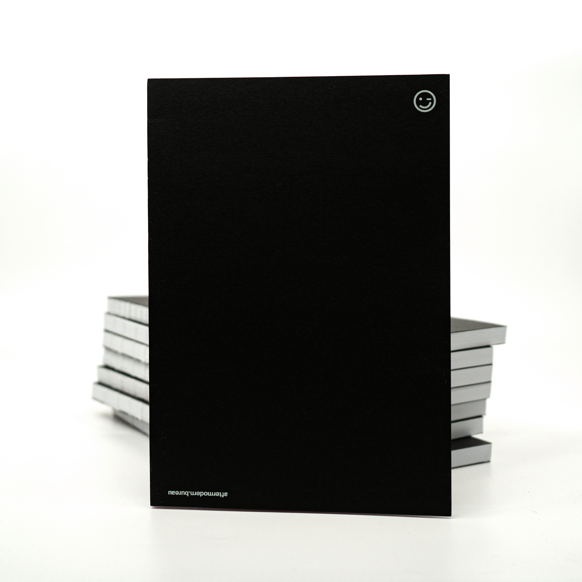 Stack of aftermodern bureau notebooks in minimal typographic covers.